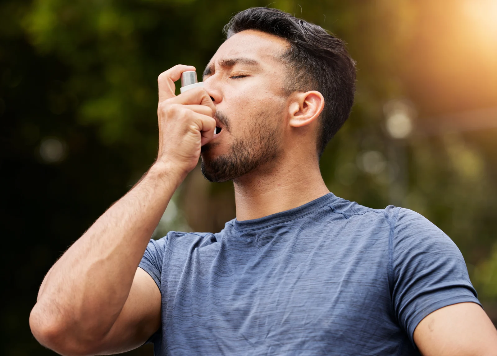 Man using a rescue inhaler outdoors